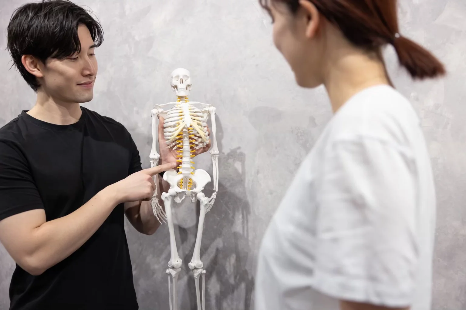 骨格模型を使って身体の仕組みや動き方をわかりやすく説明するトレーナー